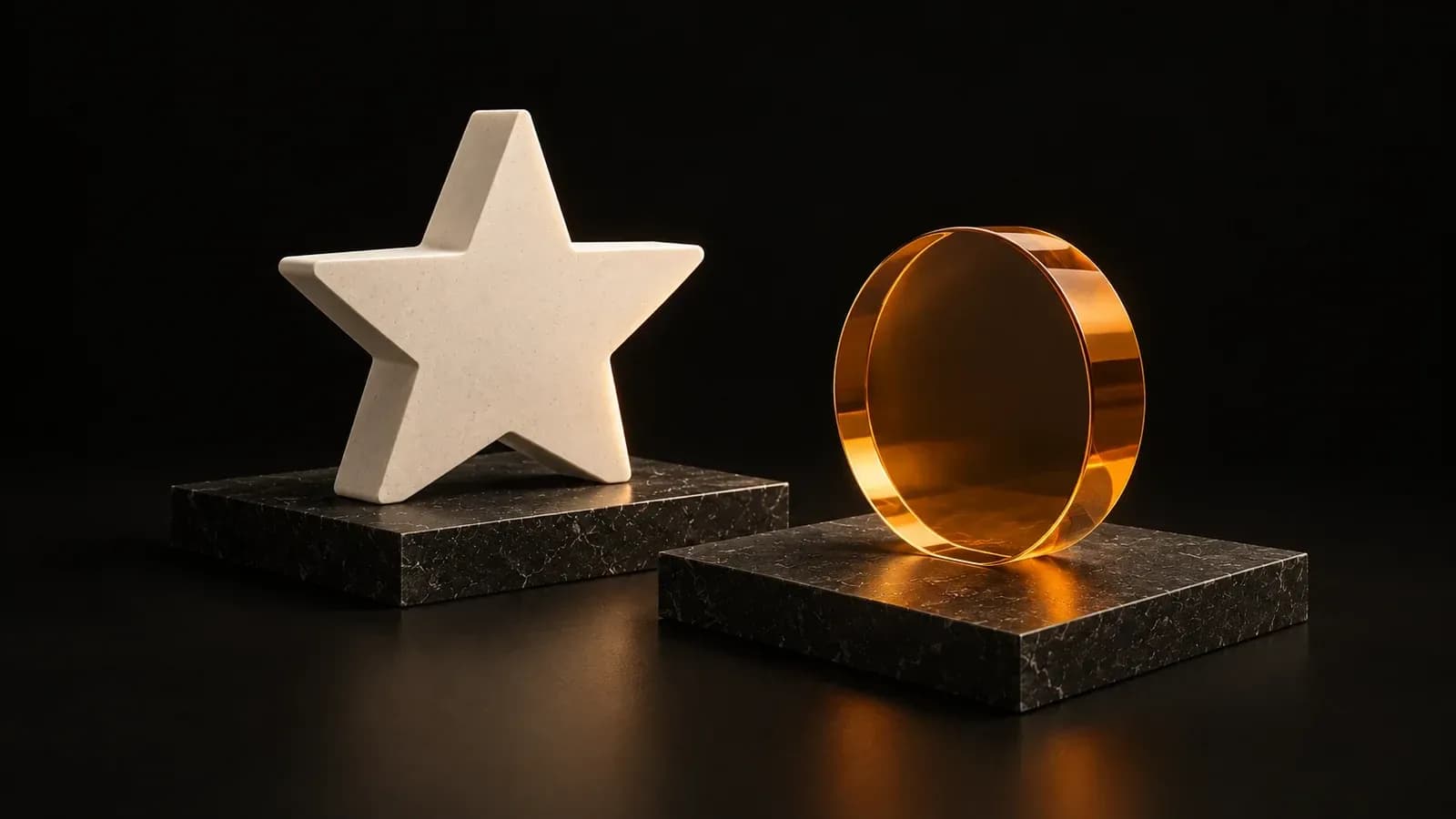 An ivory star and an amber glass disc on two separate charcoal plinths